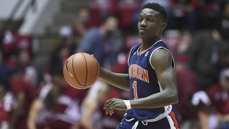 Jared Harper (1) dribbles the ball.
