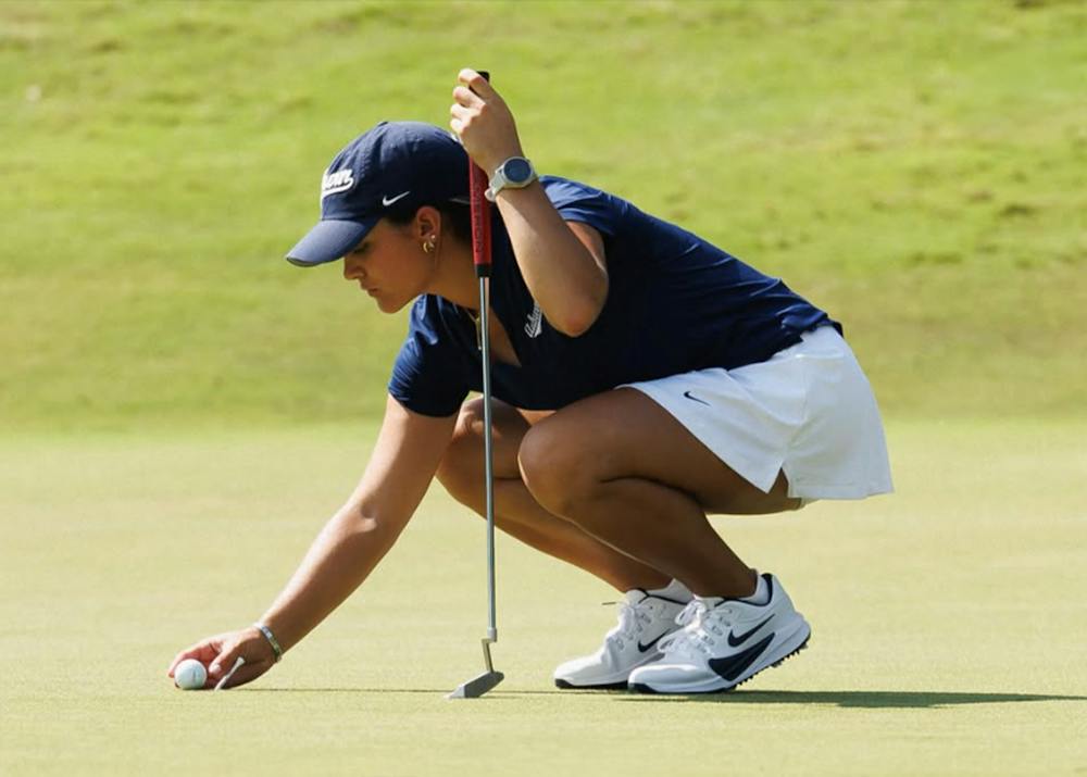 Auburn women’s golfer Gia Raad crouches on the green to line up a putt during the Haskins Intercollegiate.