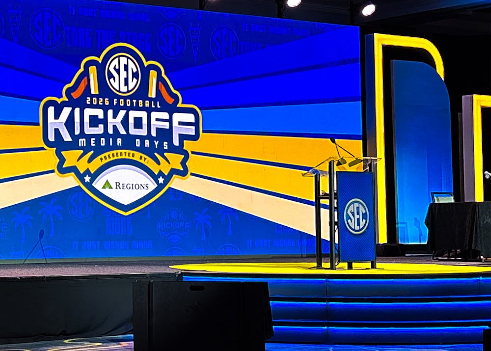 An empty SEC-branded podium stands on the stage at 2026 SEC Football Kickoff Media Days in front of a large screen displaying the event logo.