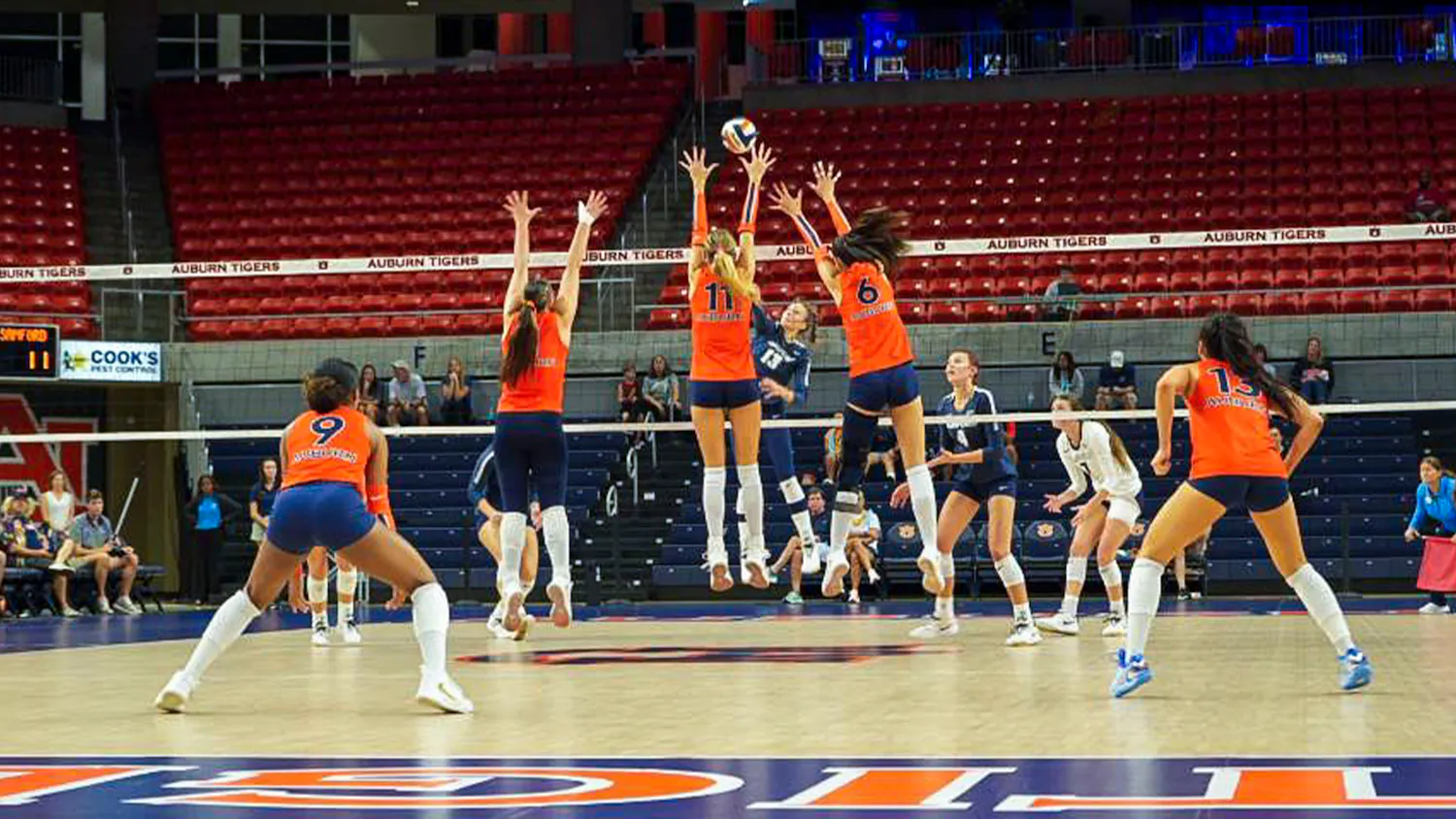 Auburn volleyball players jump at the net to block a South Alabama attack during a match at Neville Arena.