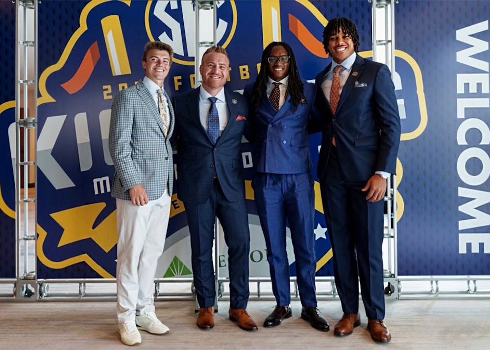 From left to right, Auburn placekicker Alex McPherson, head coach Alex Golesh, linebacker Champ Anthony and offensive lineman Byrum Brown pose together in front of an SEC Media Days backdrop during the 2026 SEC Football Kickoff Media Days.