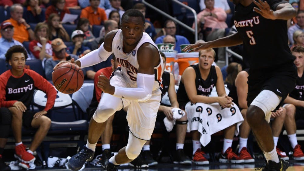 Auburn men's basketball player dribbling against Barry University