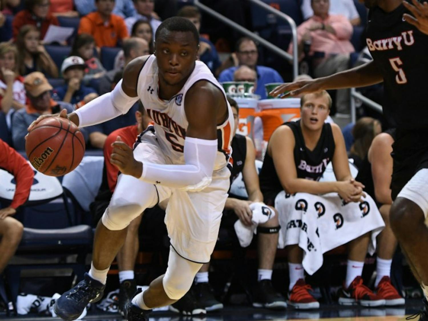 Auburn men's basketball player dribbling against Barry University