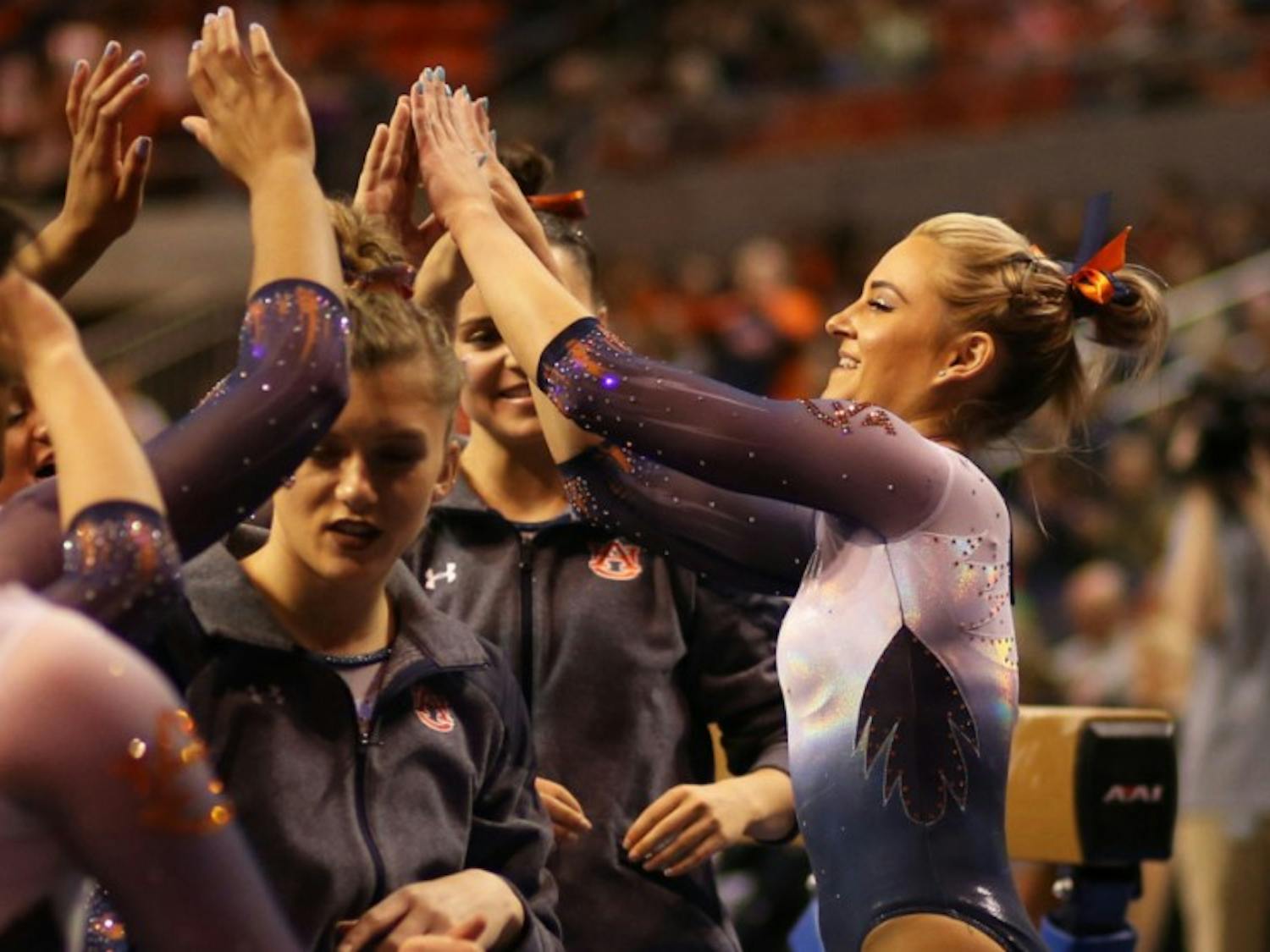 Auburn Gymnast gives high-fives to teammates
