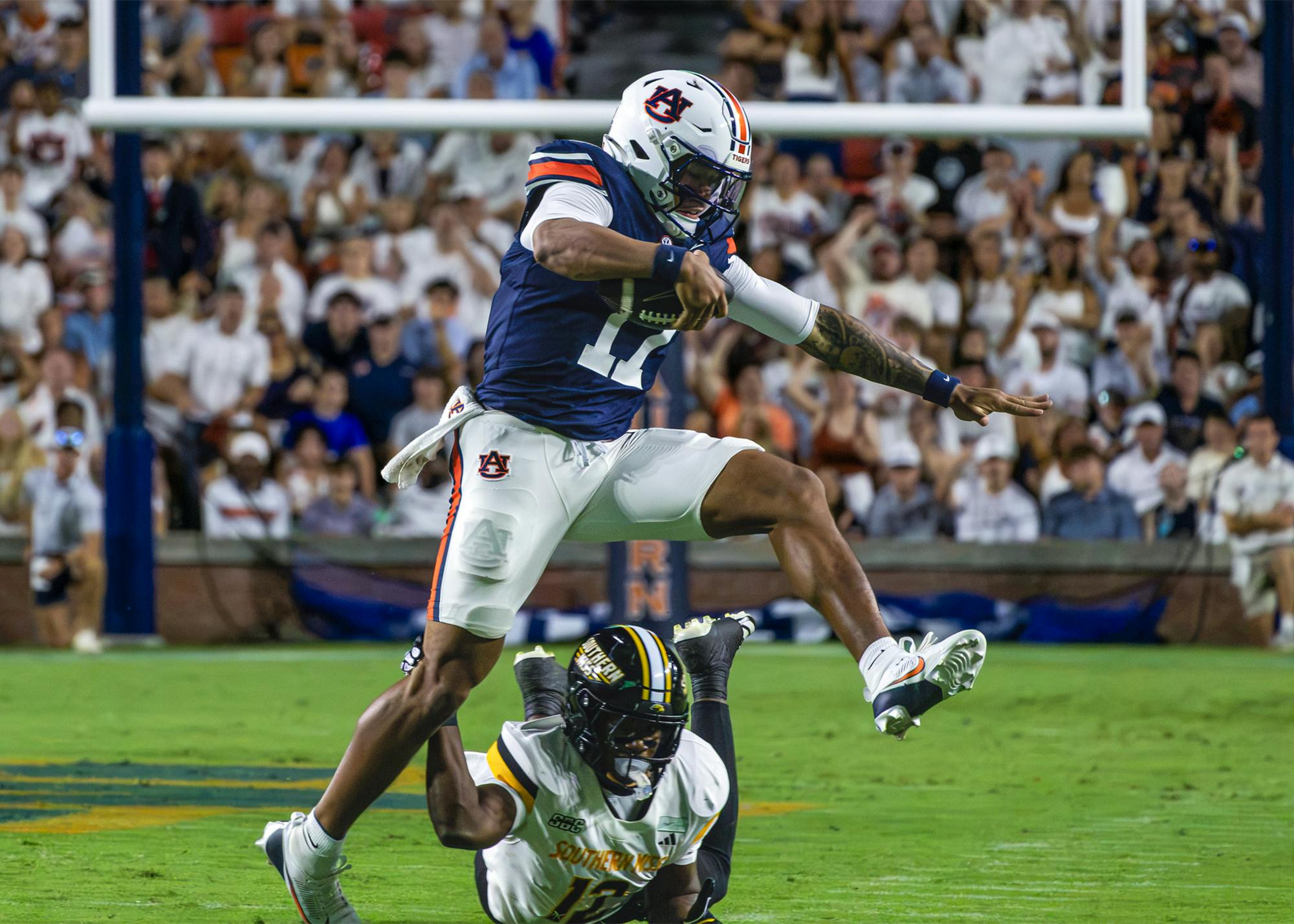Auburn quarterback Byrum Brown leaps over a Southern Miss defender during Auburn’s 43-8 victory at Jordan-Hare Stadium.