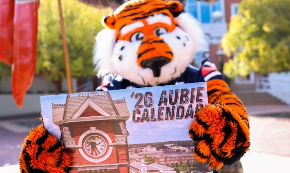 Aubie the Tiger holding up 2026 Aubie-themed calendar