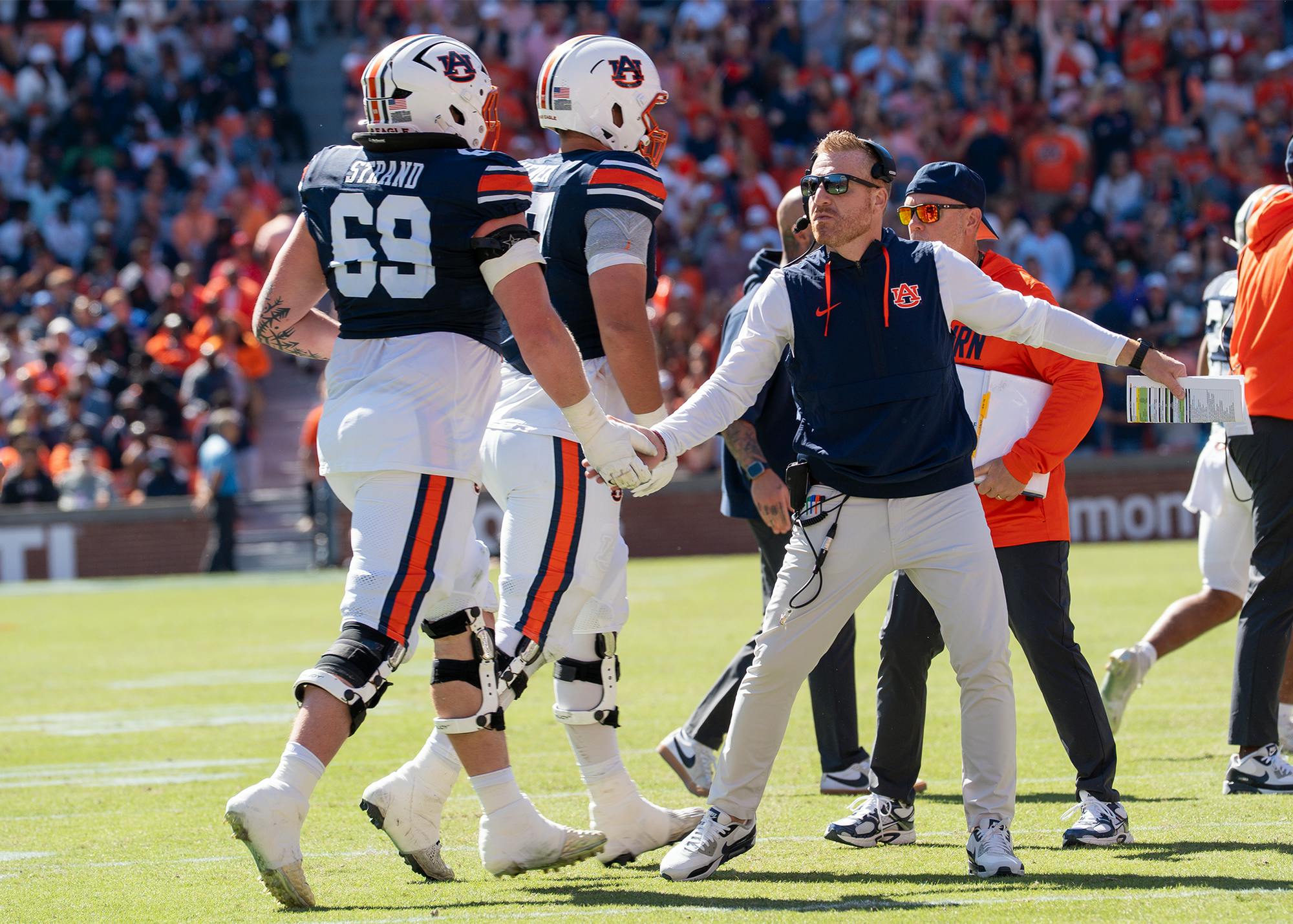 Auburn head coach Alex Golesh high-fives players as they leave the field during the game against LSU at Jordan-Hare Stadium.