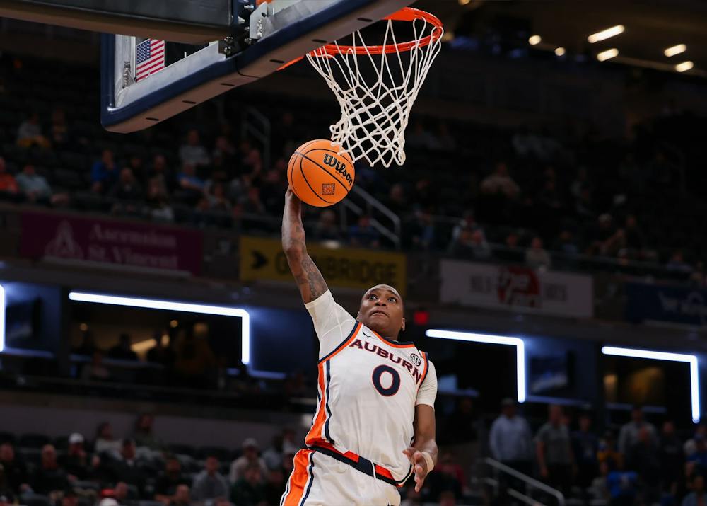 Auburn guard Tahaad Pettiford dunks the basketball.