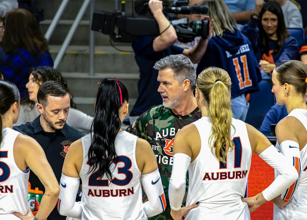 Auburn volleyball head coach Brent Crouch speaks with players during a timeout.