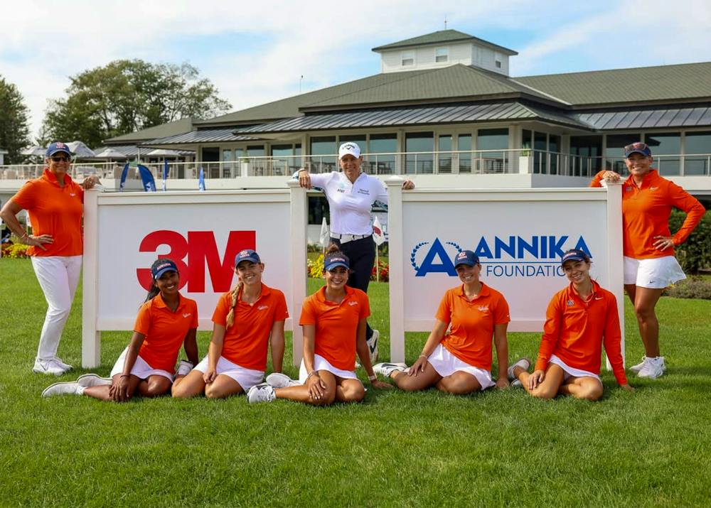 Auburn women’s golf players pose for a team photo at the ANNIKA Intercollegiate, with ANNIKA Foundation and 3M signs behind them.