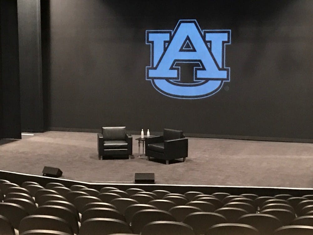 Chairs set up on stage for conversation with Tim Cook
