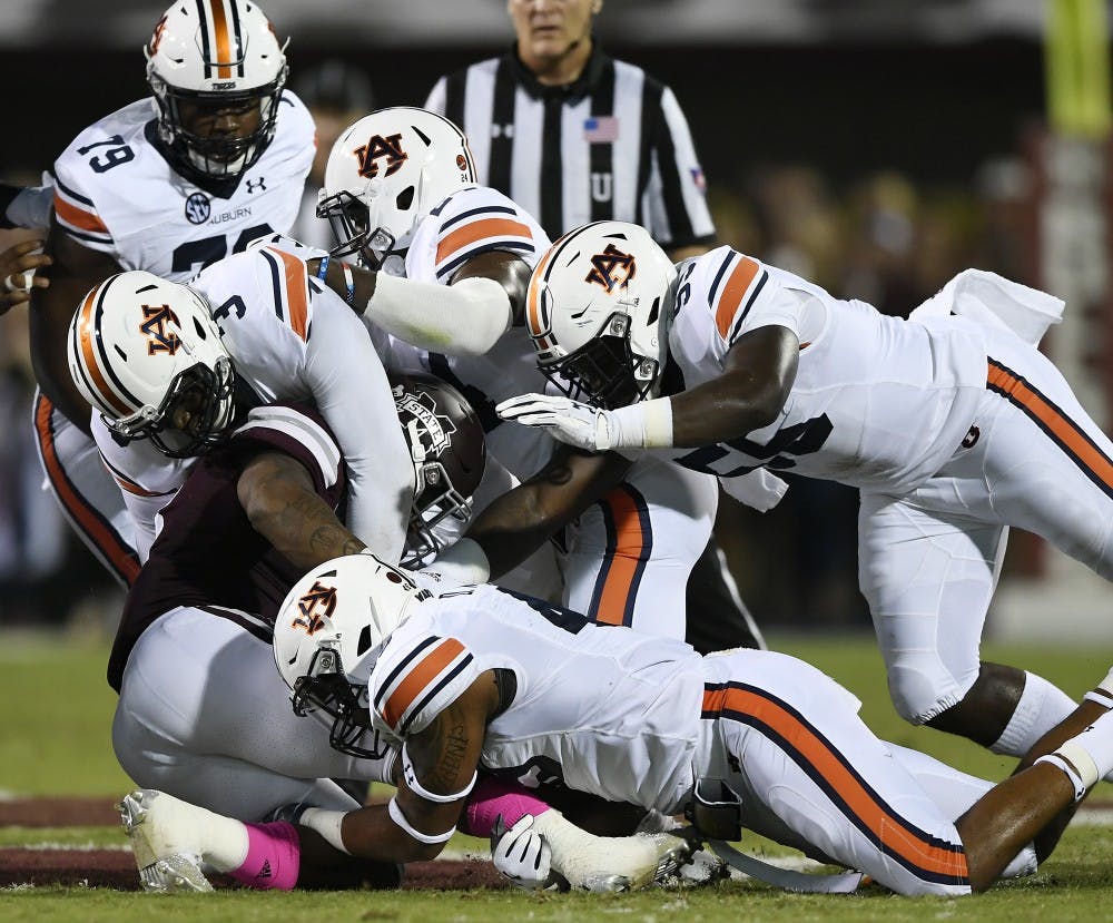 Auburn defenders Montravious Atkinson and Marlon Davidson tackle State's Kylin Hill in the first half.Auburn at Miss State football on Saturday, Oct. 6, 2018 in Starkville, MsTodd Van Emst/AU Athletics 