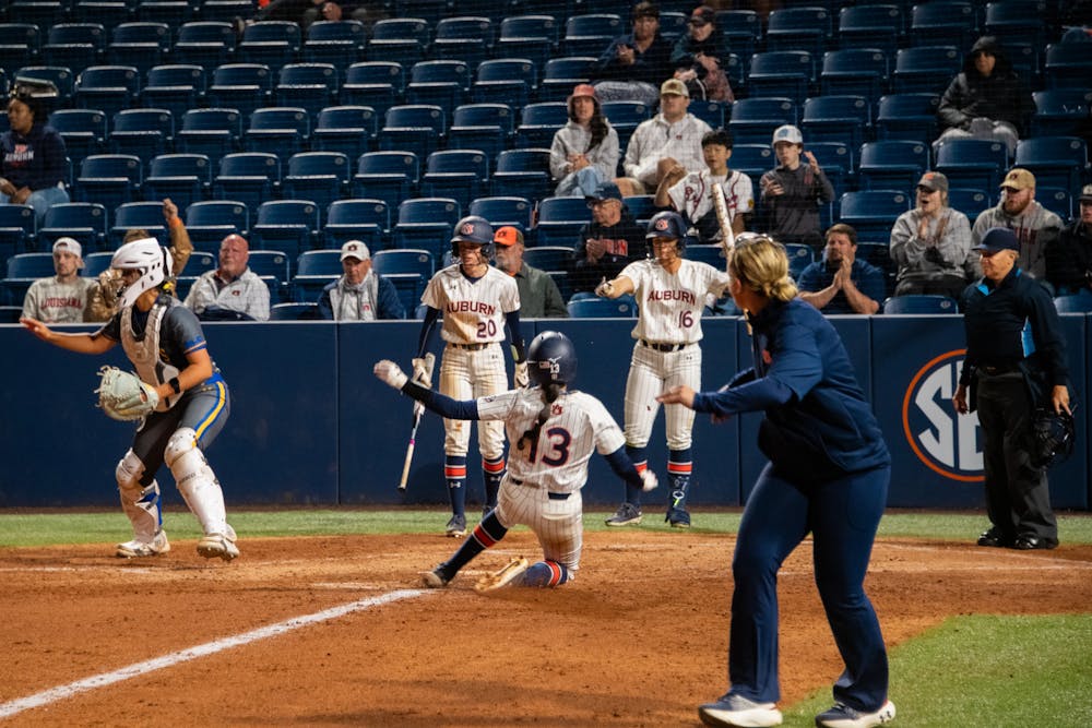 Infielder Nelia Peralta (13) sliding into home plate and scoring the Auburn Tigers another point in their game against McNeese State on Feb. 28, 2025. Photo by Cole Peake | The Auburn Plainsman