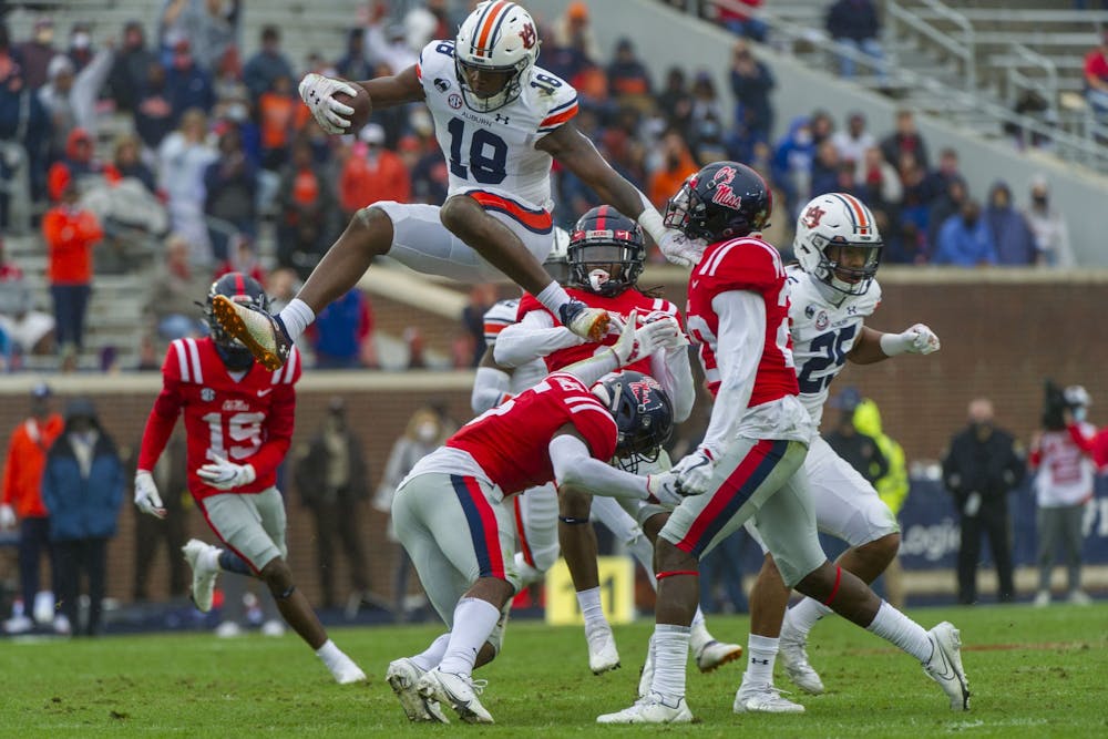 Oct 24, 2020; Oxford, Mississippi, USA;  Auburn Tigers wide receiver Seth Williams (18) leaps over Mississippi Rebels defensive back Jon Haynes (5) during the first half at Vaught-Hemingway Stadium. Mandatory Credit: Justin Ford-USA TODAY Sports