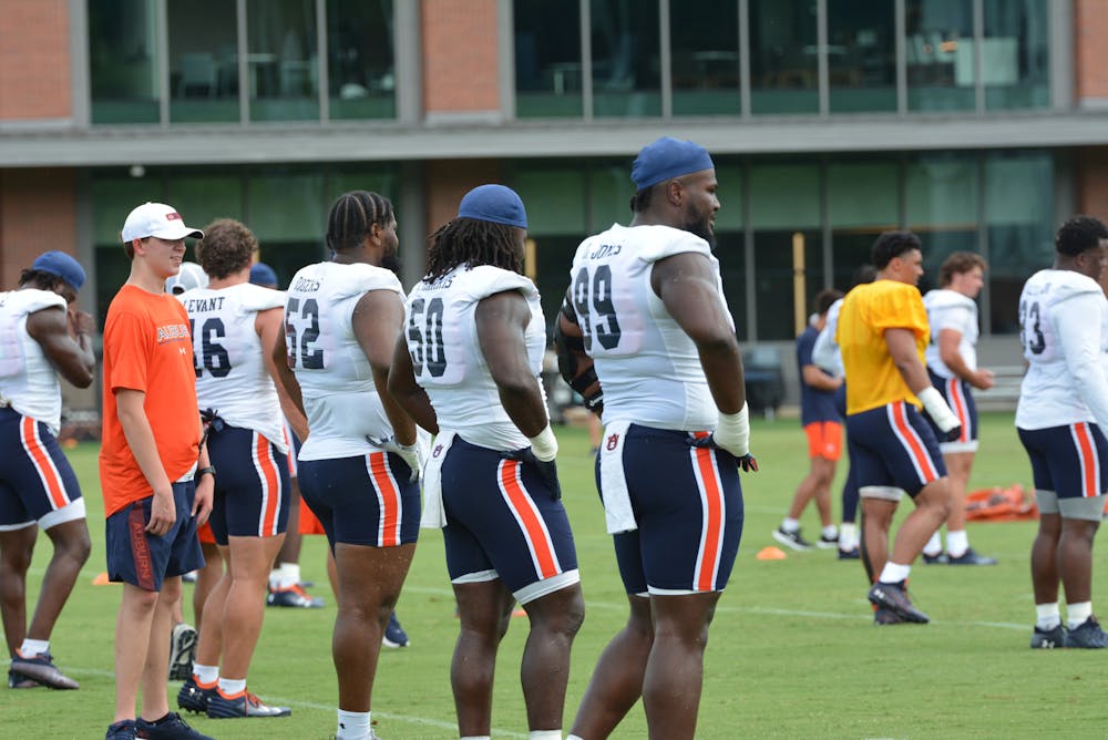 <p>Justin Rogers (52), Marcus Harris (50) and Jayson Jones (99) standing at Auburn's football practice at the Woltosz Football Performance Center on Aug. 4, 2023.</p>