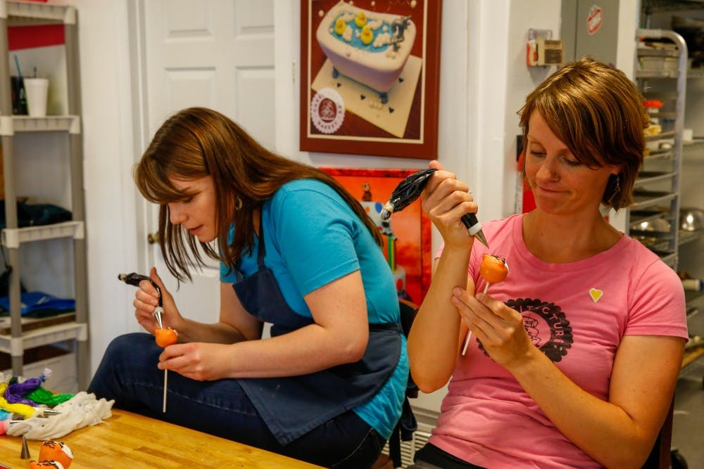 _ and _  work on decorating Aubie cake pops in Auburn, Ala. on Tuesday, August 16, 2016.