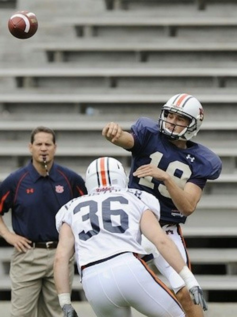 Auburn quarterback Neil Caudle throws under pressure from defender Wade Christopher in the second half of thier NCAA college footbal spring A-day game on Saturday, April 18, 2009 in Auburn, Ala. Coach Gene Chizik is in the background. Todd Van Emst