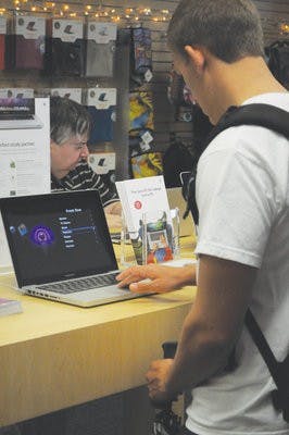 Jimmy Cooper, sophomore in supply chain and aviation management, looks at a computer in the Mac store on campus. (Christen Harned / ASSISTANT PHOTO EDITOR)