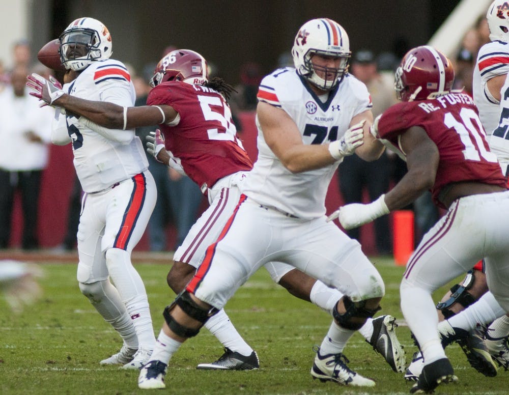 Jeremy Johnson (6) gets hit by Alabama's Tim Williams (56) as he throws a pass in the first half. Auburn vs Alabama on Saturday, Nov. 26 in Tuscaloosa, AL.