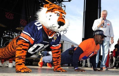 Aubie and Mr. Penny do push-ups during a pep rally in Glendale, Ariz., after he was given an all-expense-paid trip. (Todd Van Emst / Auburn Media Relations)