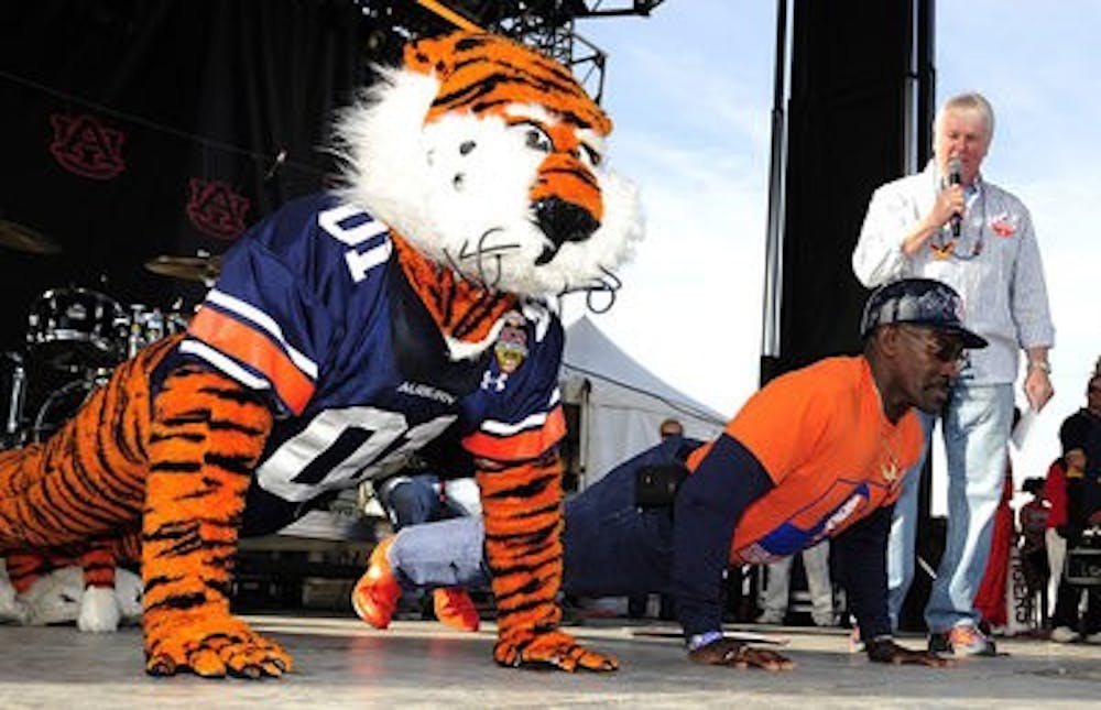 Aubie and Mr. Penny do push-ups during a pep rally in Glendale, Ariz., after he was given an all-expense-paid trip. (Todd Van Emst / Auburn Media Relations)