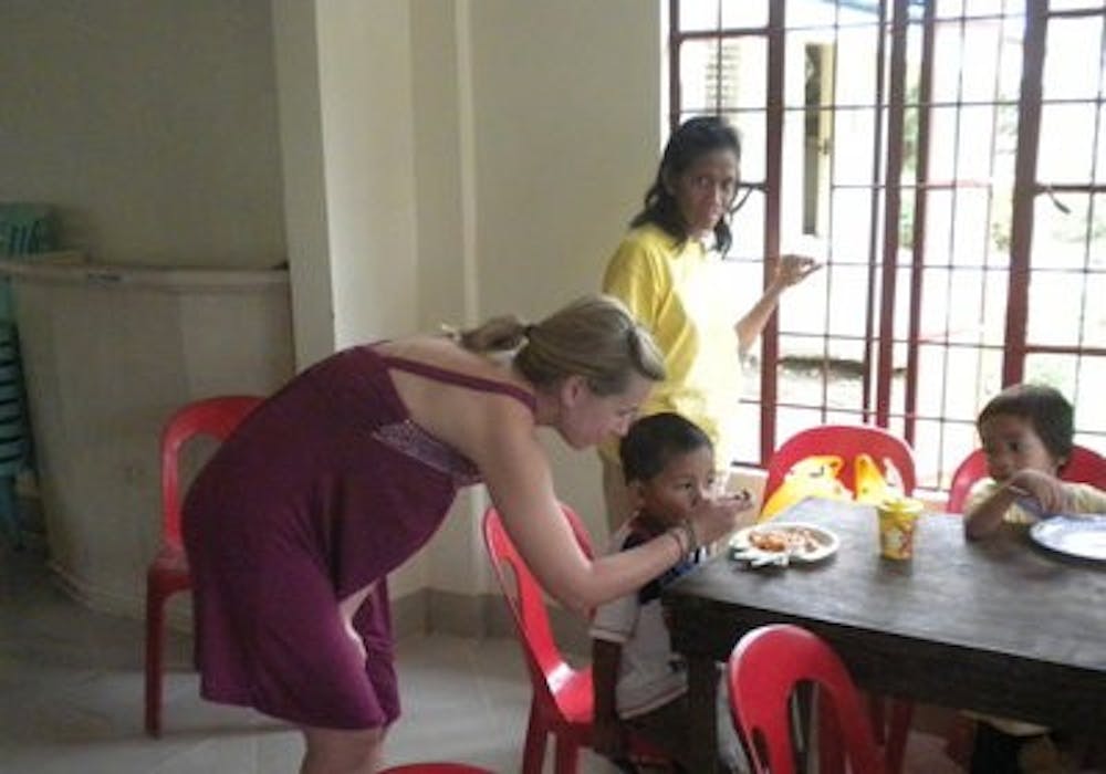 Jenna McClure, senior in nutrition, feeds one of the 35 children she helped in the Philippines during winter break. (Contributed)