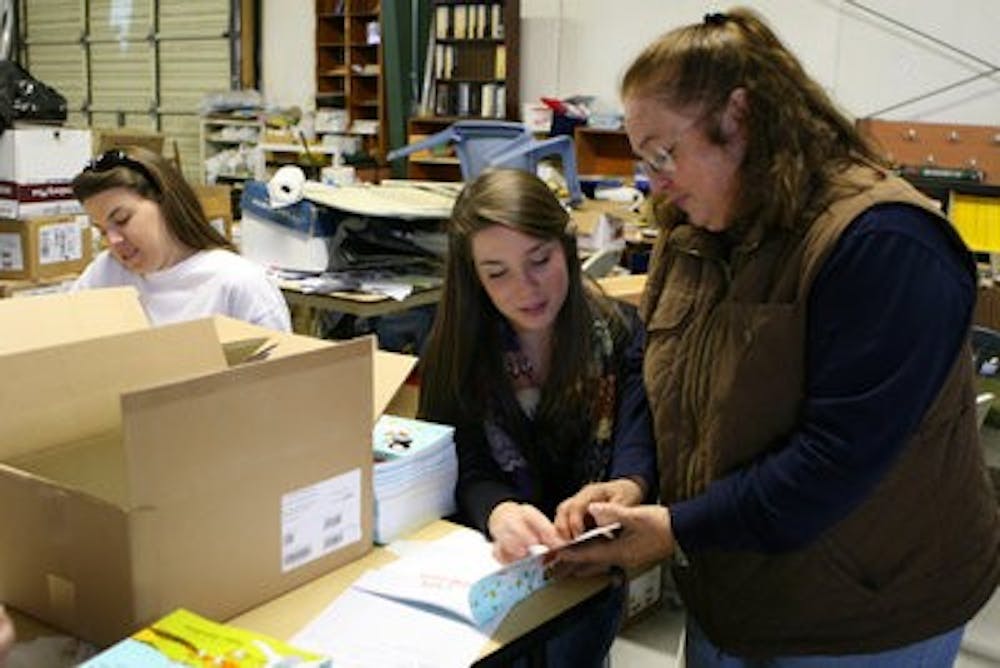 Cathy Dean Gafford, right, helps students from IMPACT sort and box books at the Jean Dean RIF in Opelika Monday afternoon. (Rebecca Croomes / PHOTO EDITOR)
