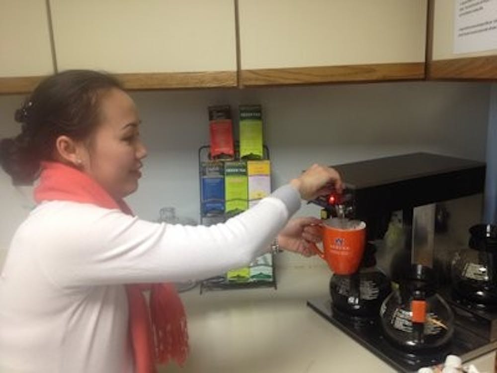 Marketing instructor, Jasmine Le, gets coffee using the mugs. (Contributed by Joseph McAdory)