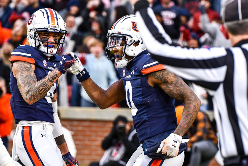 Auburn receiver Key Moore (0) daps up a teammate after scoring a touchdown in the first half against Western Kentucky in Jordan-Hare Stadium on Nov. 19, 2022.