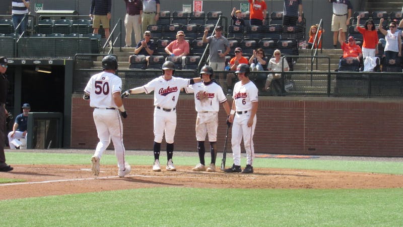 Jake Wyandt (50) celebrates with teammates Brody Moore (4), Blake Rambusch (1), and Ryan Dyal (6) after hitting a home run against Rhode Island on March 6, 2022 at Plainsman Park in Auburn, Ala.