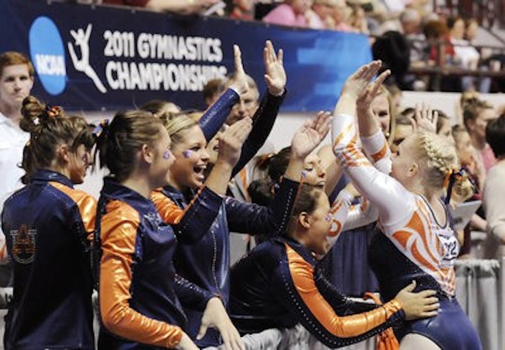 Junior Kylie Shields celebrates with the team after her bar routine at the NCAA Regional competition held in Tuscaloosa April 2. (Todd Van Emst / Auburn Media Relations)