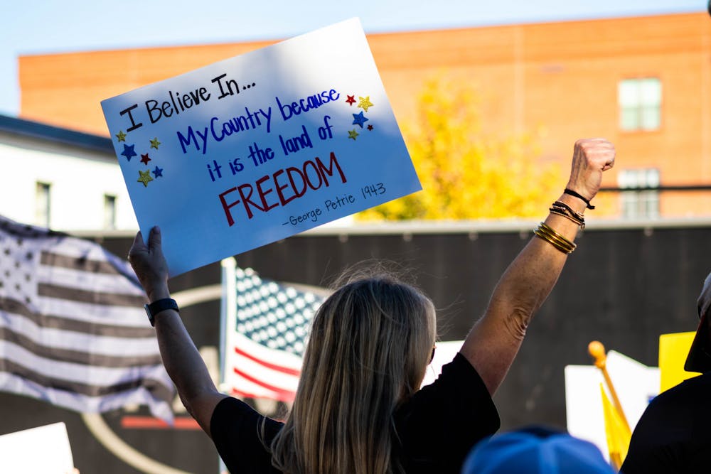 <p>A protestor holds a sign quoting part of the Auburn Creed in opposition to Auburn University's announcement that all employees must be fully vaccinated against COVID-19 in accordance with a federal executive order on Oct. 26, 2021, in Auburn, Ala.</p>