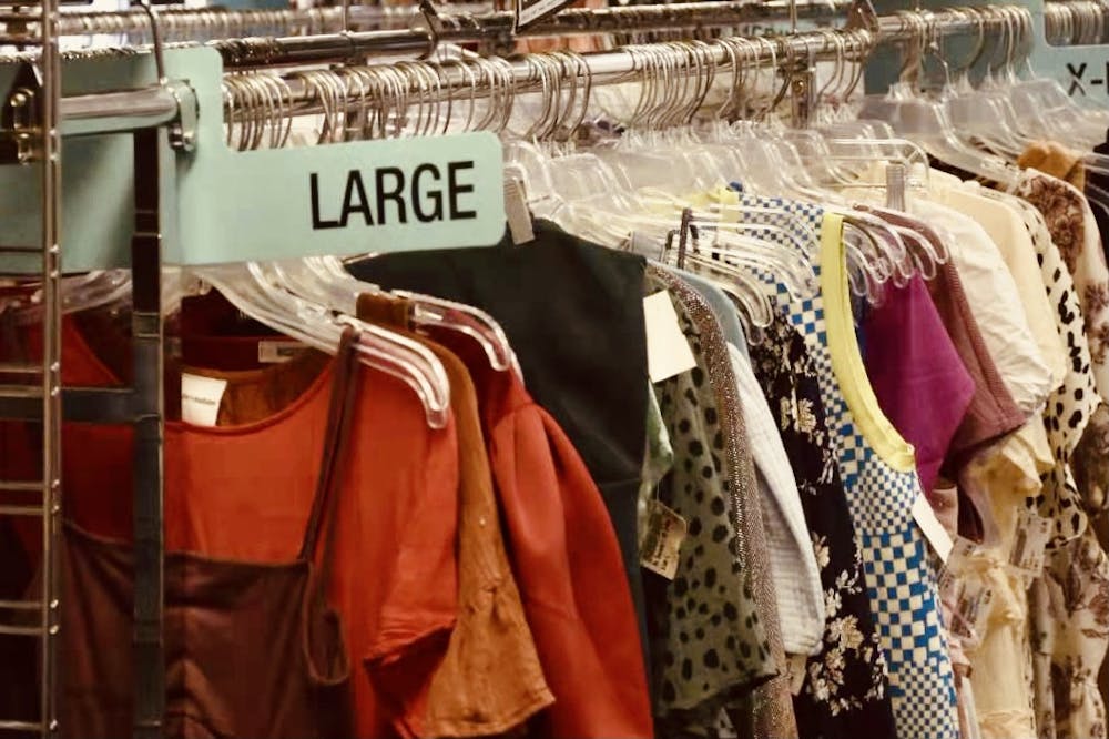 <p>Pre-loved clothing lines the racks at an Auburn thrift store.&nbsp;</p>