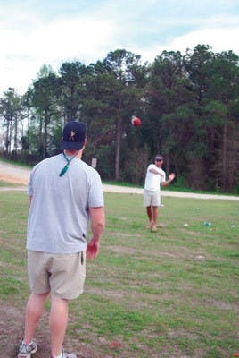 At left, Kevin Carrol, a sophomore in building science, and Trey Stephens, a sophomore in accounting, enjoy a spring day by throwing around a football at the fields off Donahue Drive.