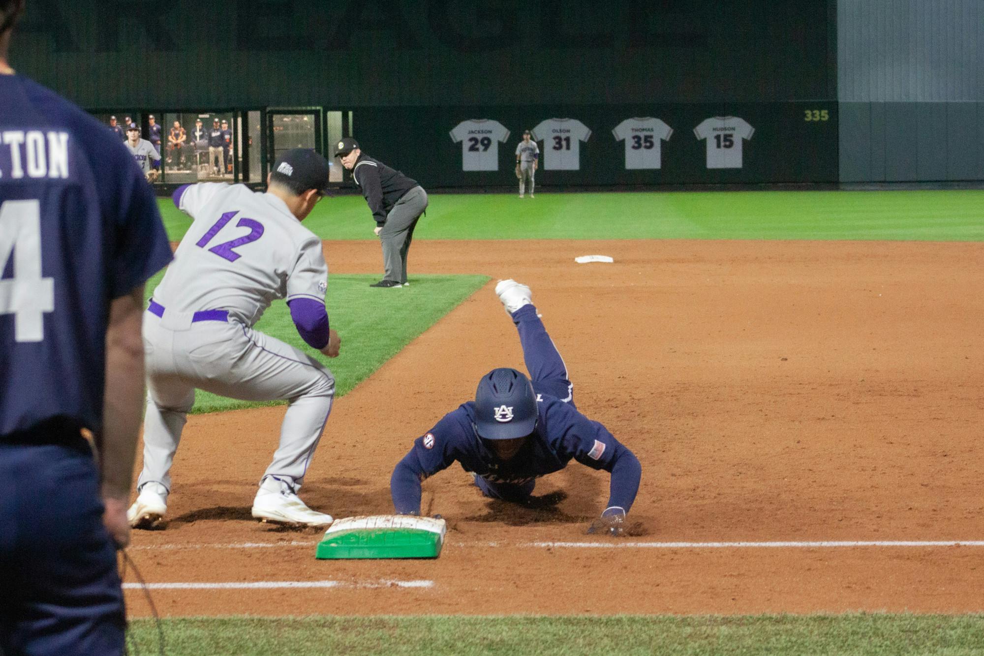 Bub Terrell diving back into first while Holy Cross pitcher tries to pick him off. Friday, February 14, 2025