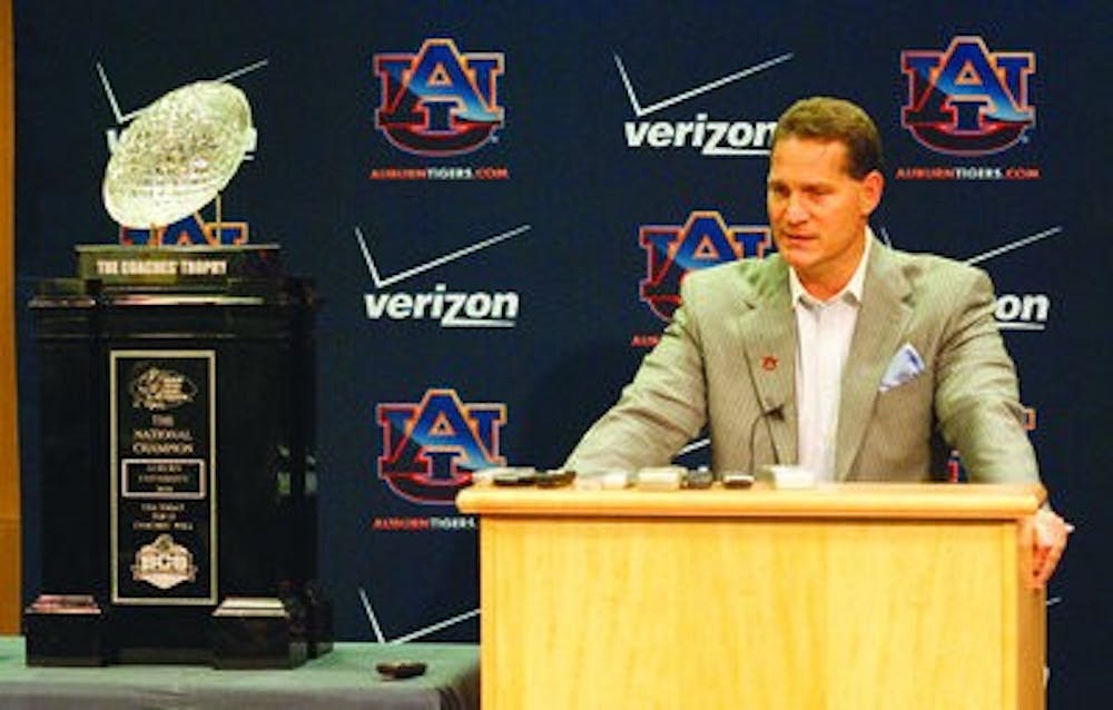 Head coach Gene Chizik stands next to the BCS Championship trophy as he discusses signing day commitments. (Emily Adams / Photo Editor)