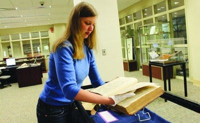 Marlise Thomas carefully examines one of the Bibles in the Special Collections exhibit. (Alex Sager / PHOTO EDITOR)