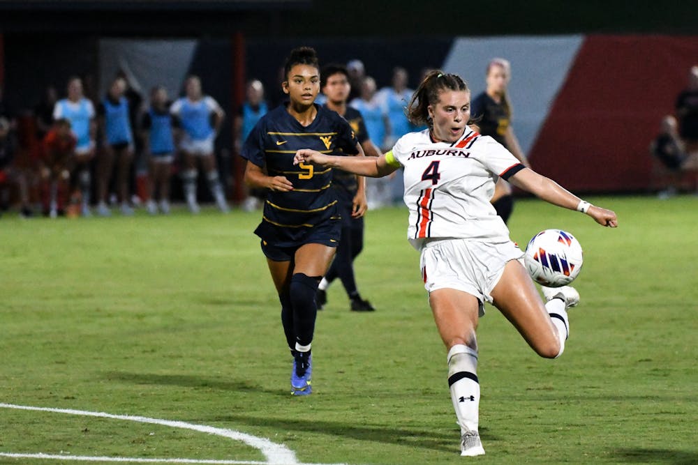 Auburn forward Anna Haddock (4) strikes a ball midair in the first half of a match between Auburn and West Virginia at the Auburn Soccer Complex on Sep. 1, 2022.