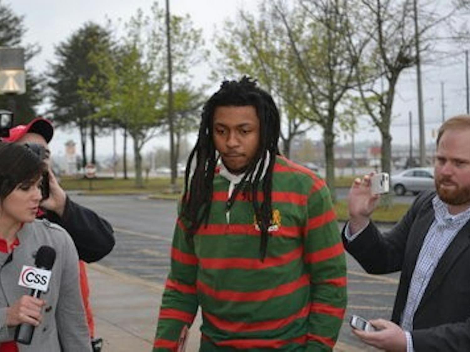 McNeil (center) walks into the Lee County Justice Center as reporters ask questions. (Raye May / PHOTO EDITOR)