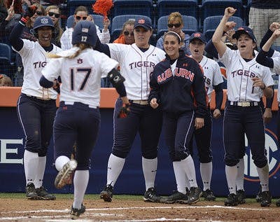 Auburn softball players wait at home plate to celebrate Branndi Melero's home run.