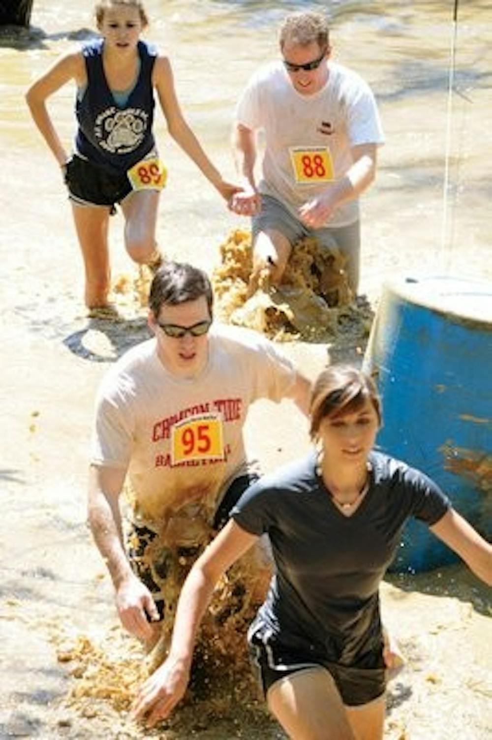 Participants wade through mud at Saturday's Mud Run. (christen Harned / assistant photo editor)