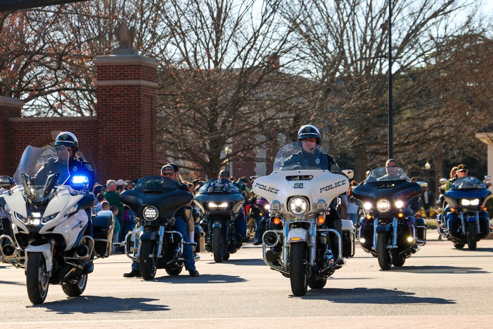 <p>Auburn police officers and bikers lead the Auburn Mardi Gras parade procession on Feb. 18, 2023.</p>