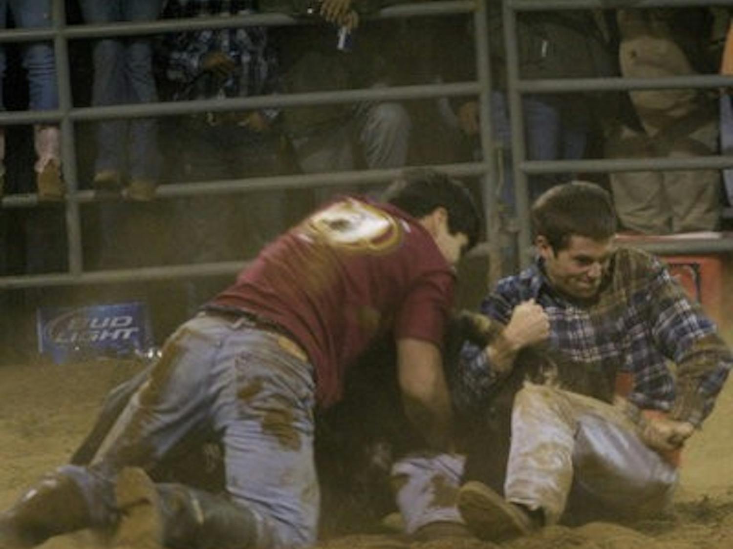 Slay Huff, junior in finance, and Trevor Ramsey, undeclared junior in sciences and math, wrestle a bull to the ground in the 2009 FarmHouse Rodeo. (CONTRIBUTED)