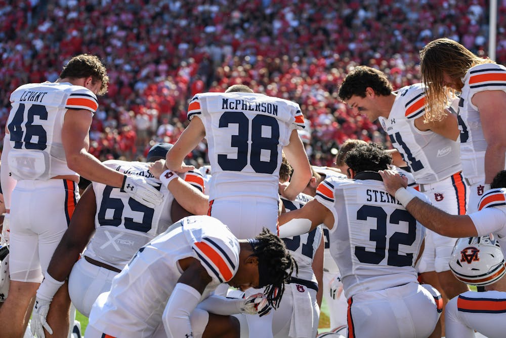 Auburn players pray in the end zone before a game against Georgia in Sanford Stadium on Oct. 8, 2022.