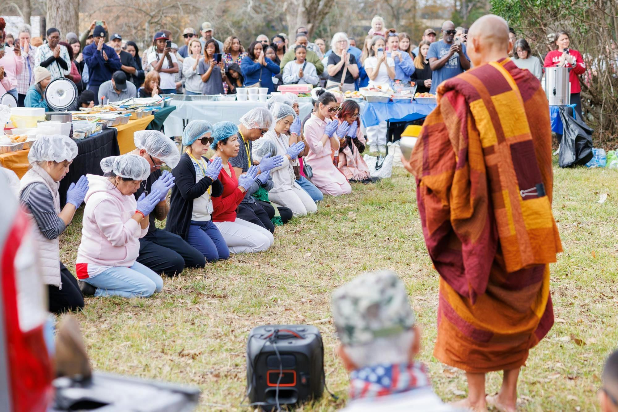Before lining up and serving themselves the monks chant to bless the food. Volunteers sit on their knees with their palms together and fingers pointed up in a gesture of respect.