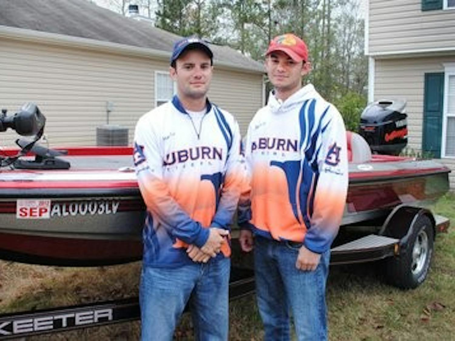 Matt Lee (left), president of bass fishing team and Jordan Lee (right), tournament director, pose by their boat. (Maria Iampietro / PHOTO EDITOR)