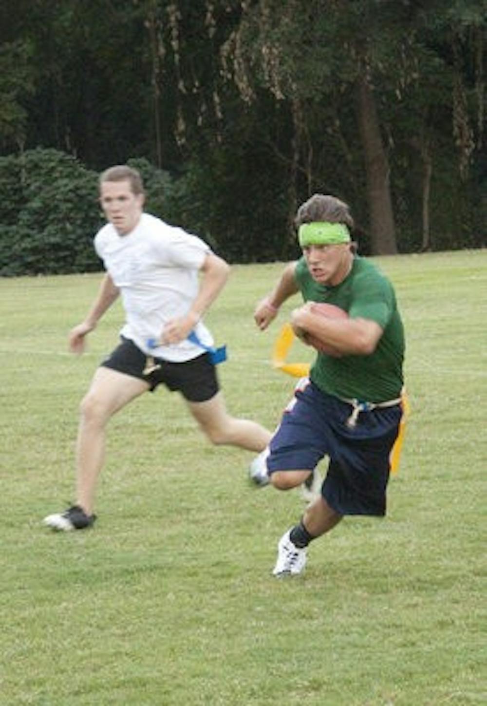 Senior Tyler Cooke races by junior Grant Campbell at the intramural fields Monday night. (Emily Adams / Photo Editor)