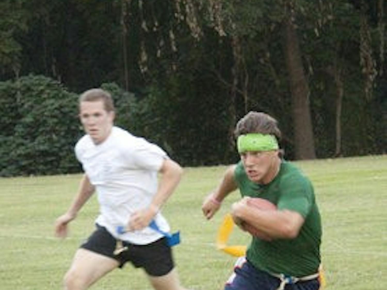Senior Tyler Cooke races by junior Grant Campbell at the intramural fields Monday night. (Emily Adams / Photo Editor)