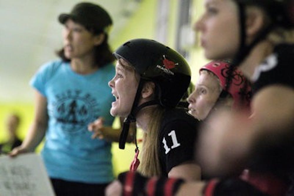 Amyn Atcha cheers on the Burn City Rollers. The all-girl roller derby team will compete in 13 bouts in the 2011 season. (Emily Adams / PHOTO EDITOR)