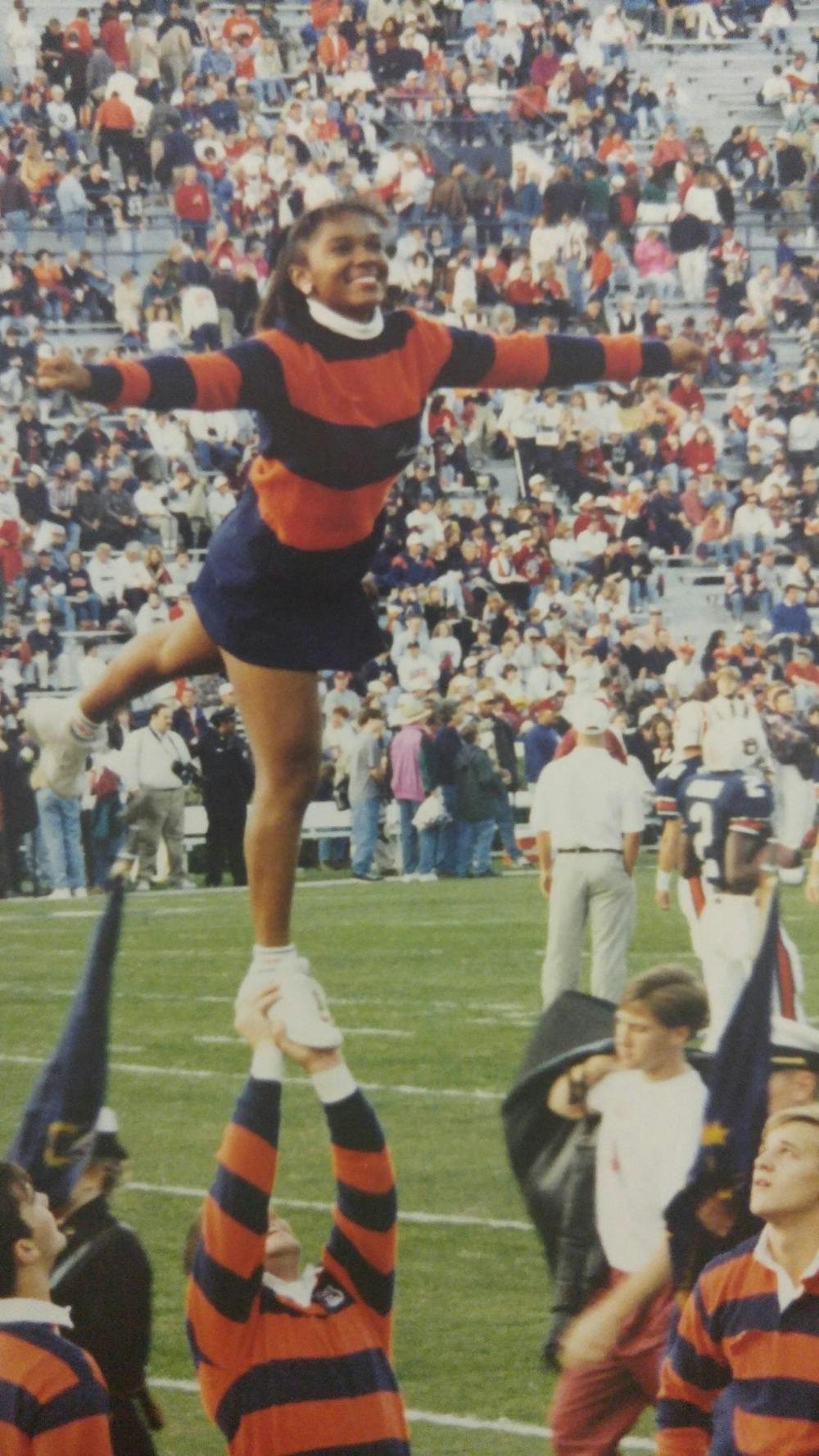 Wearing an orange and blue sweater, Danyelle Hillman is lifted and poses for a stunt. Contributed by Danyelle Hillman. 